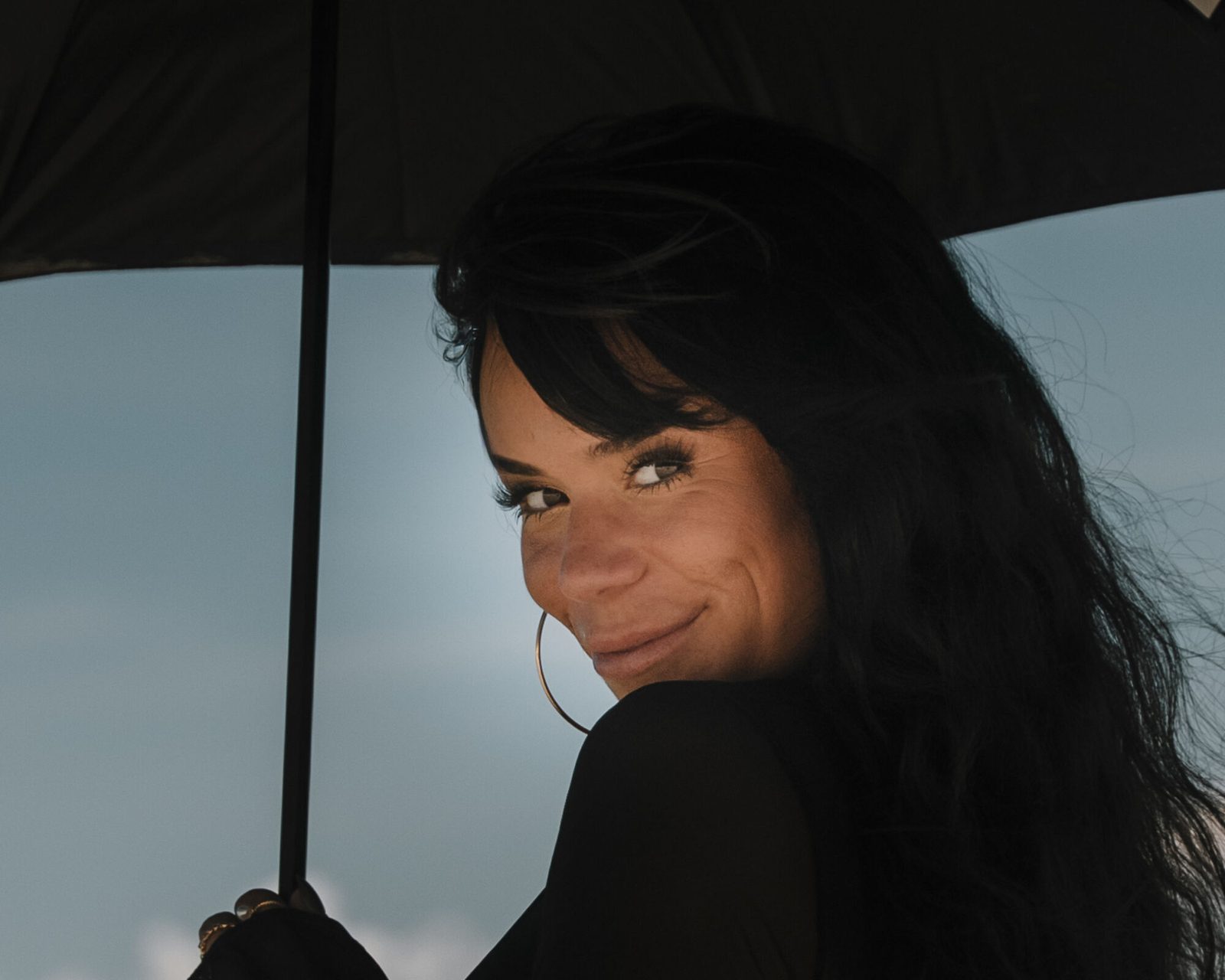 Tight portrait beneath the umbrella against open sky