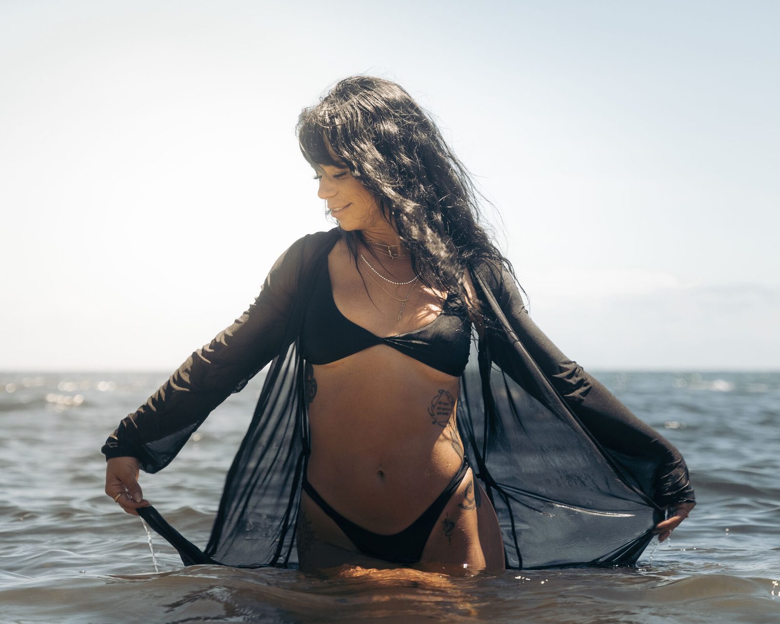 Sheer black cover-up open in backlit water