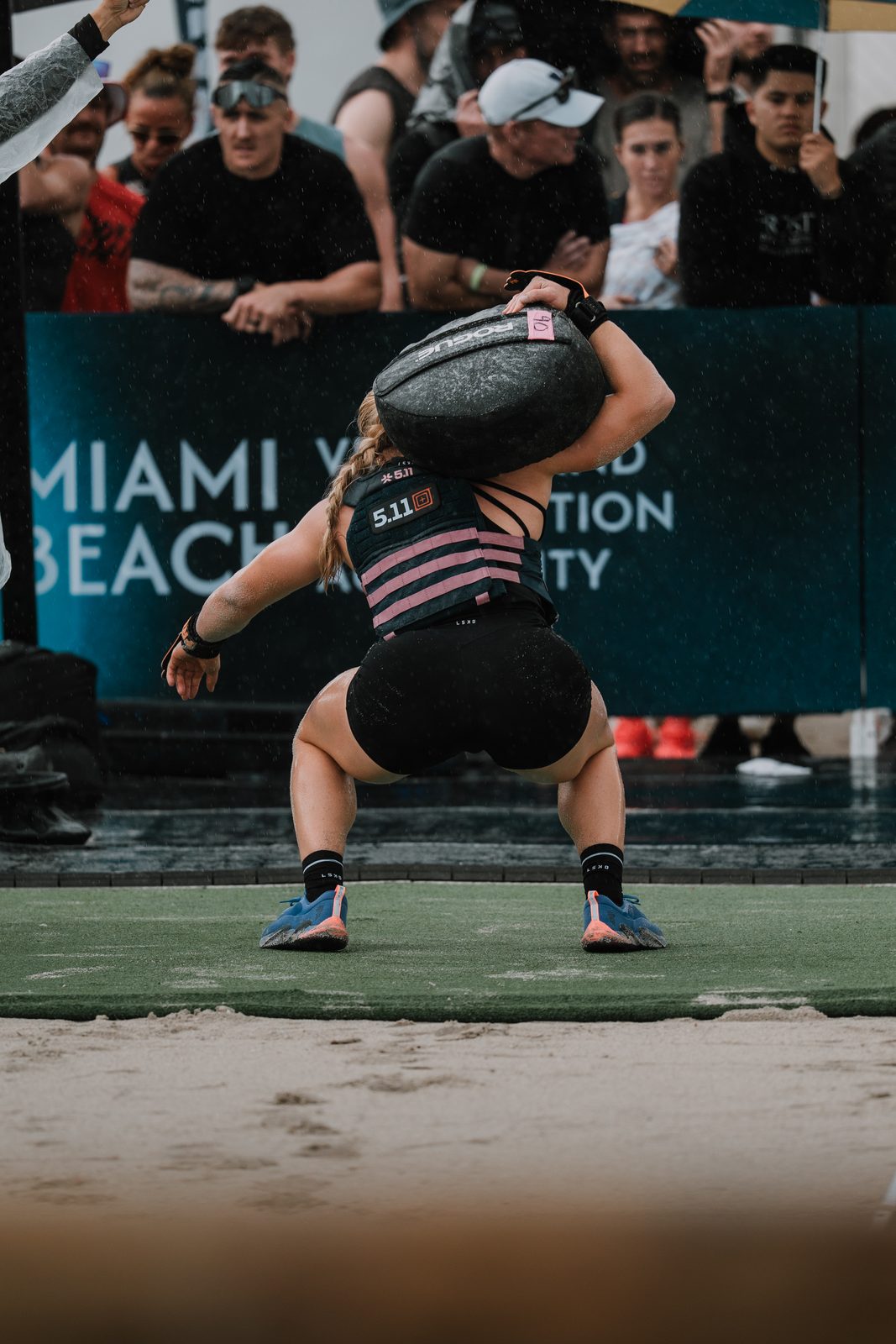 Squatting under a sandbag on the beach, seen from behind