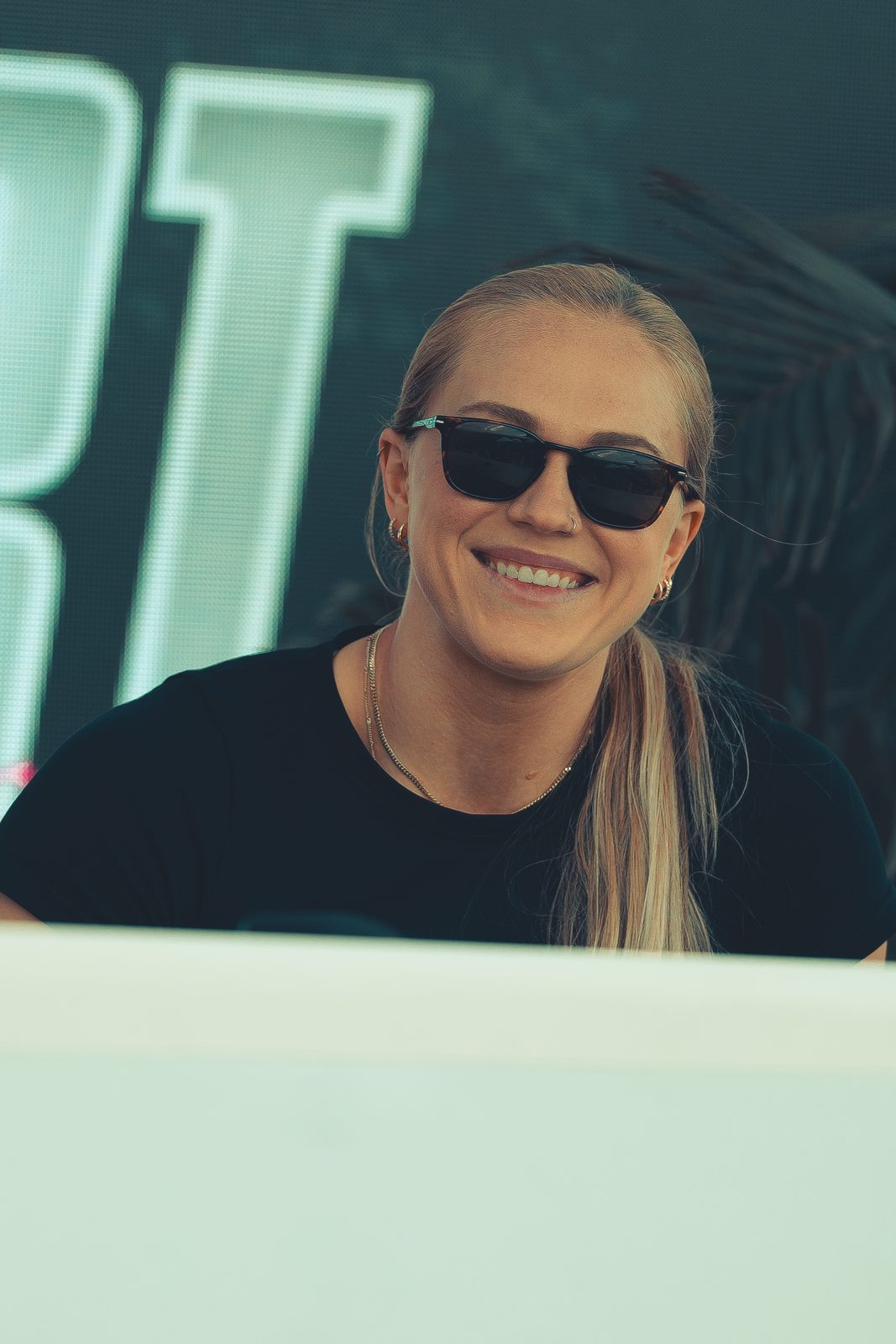 Off the floor in sunglasses, grinning